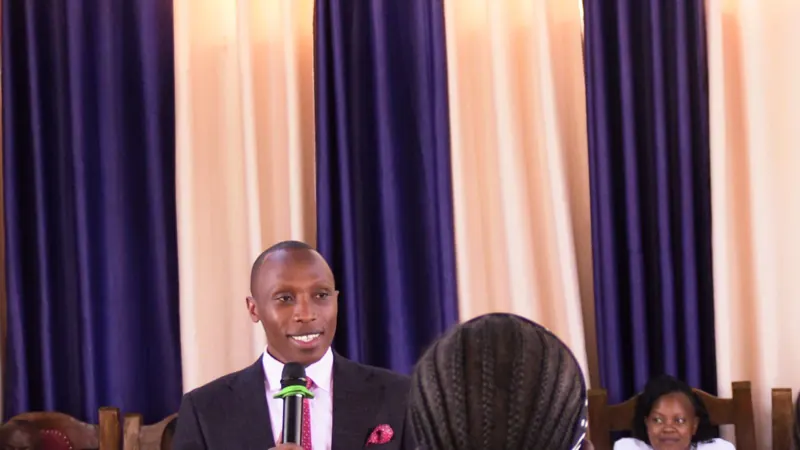 Simon Mugetha smiling as he speaks into a microphone