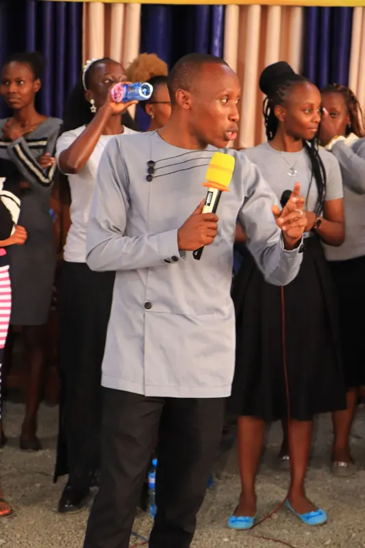 Simon Mugetha on stage with a youth group